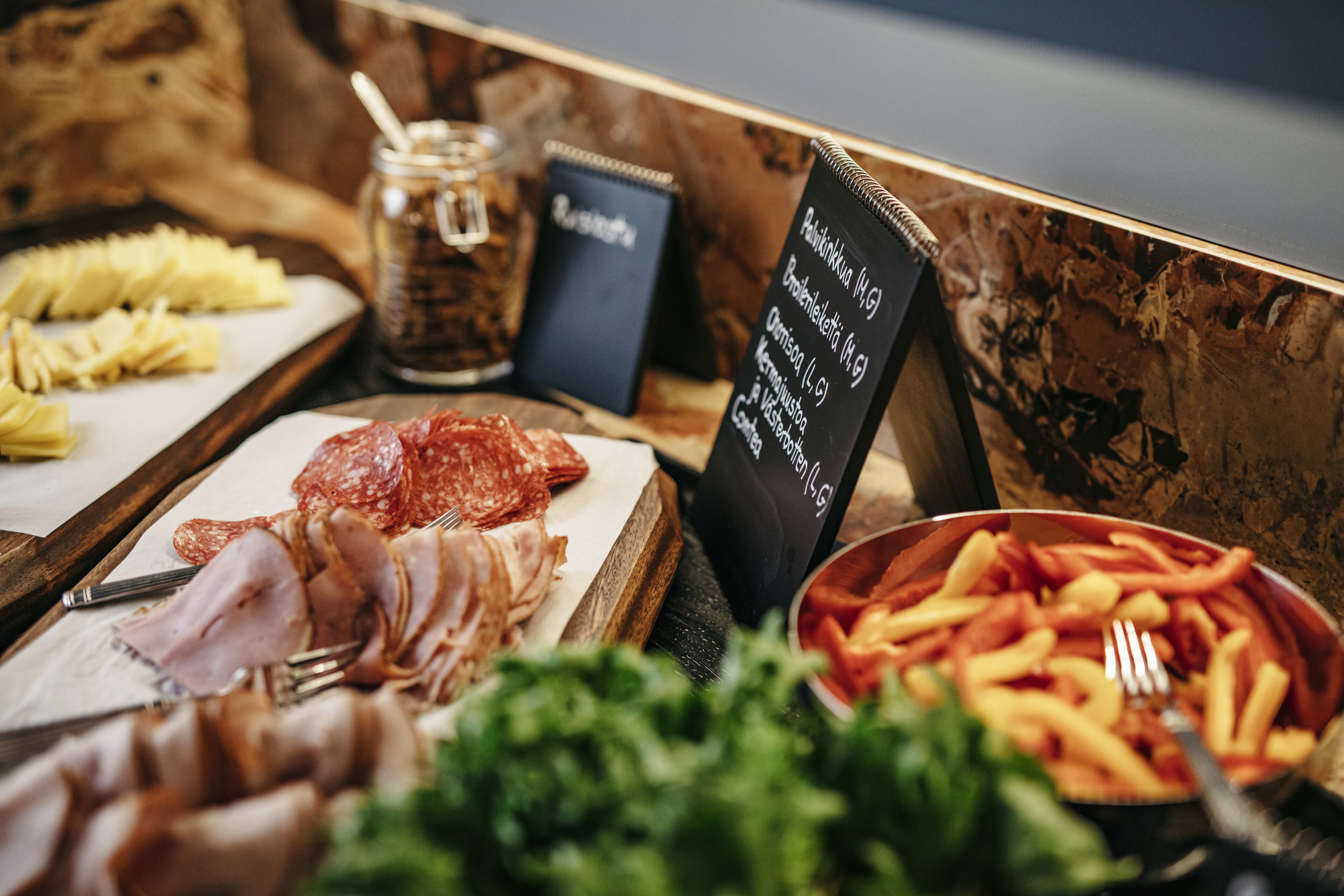 Un bufé con diversos alimentos, incluyendo carnes, frutas y verduras.