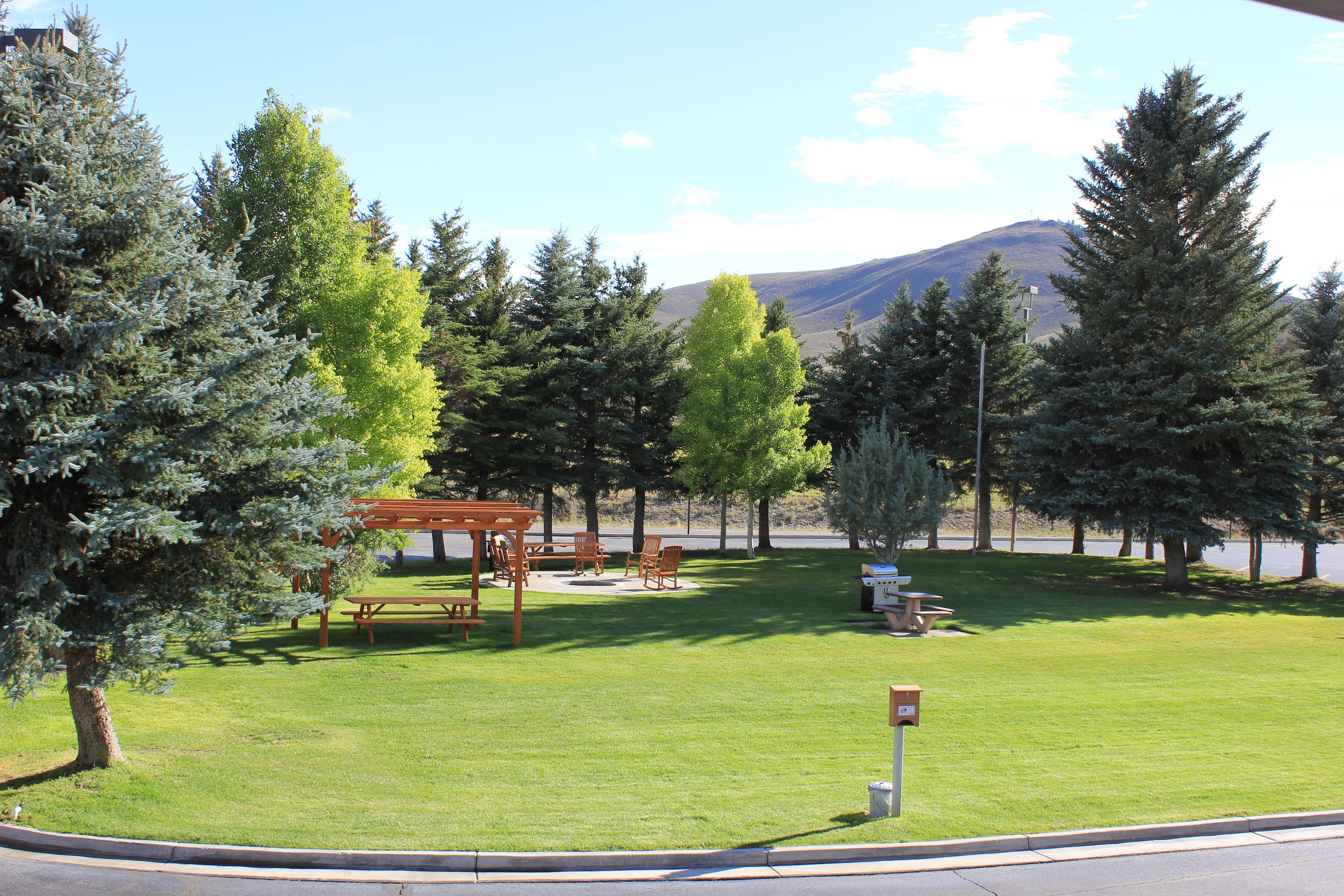 A park with picnic tables, benches, and a gazebo.