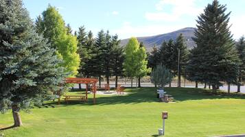 A park with picnic tables, benches, and a gazebo.