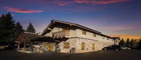 A two-story building with a registration sign, stone facade, and a parking area.