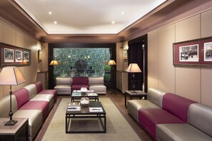 Une chambre d’hôtel moderne dotée d’une grande fenêtre, de fauteuils confortables et d’une table basse.