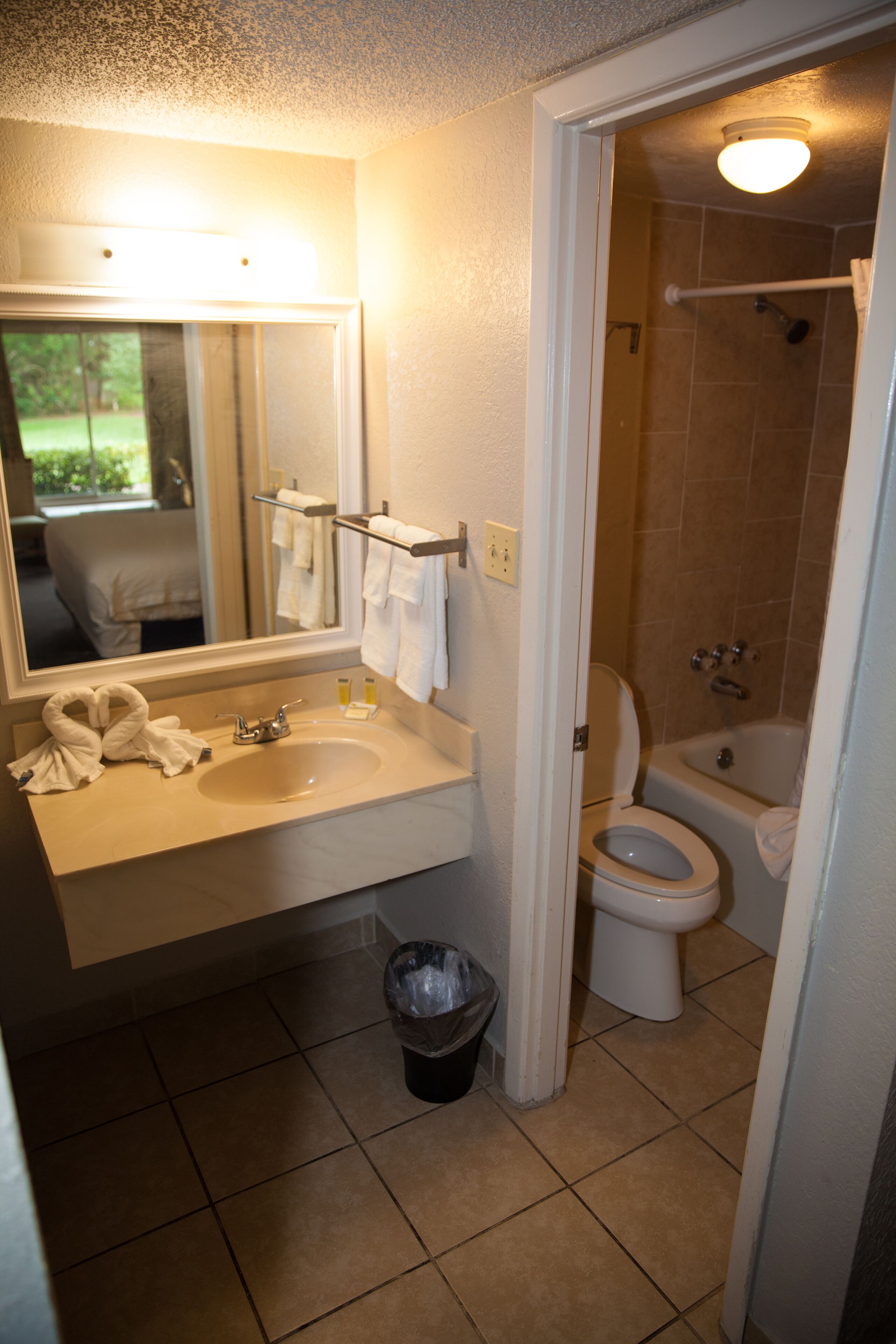 Un baño con lavamanos, espejo e inodoro.