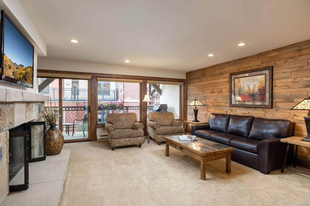 A living room with a fireplace, two armchairs, a sofa, and a coffee table.