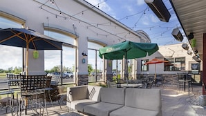 An outdoor seating area with tables, chairs, and umbrellas.