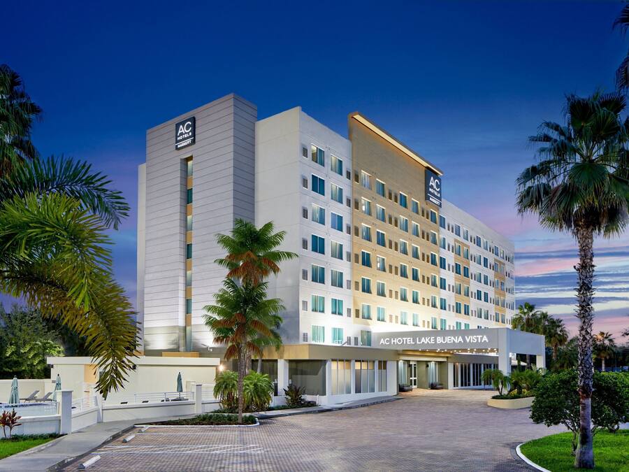 Un hotel moderno con fachada plana, varios pisos y un letrero llamativo que dice "AC HOTEL LAKE BUENA VISTA".