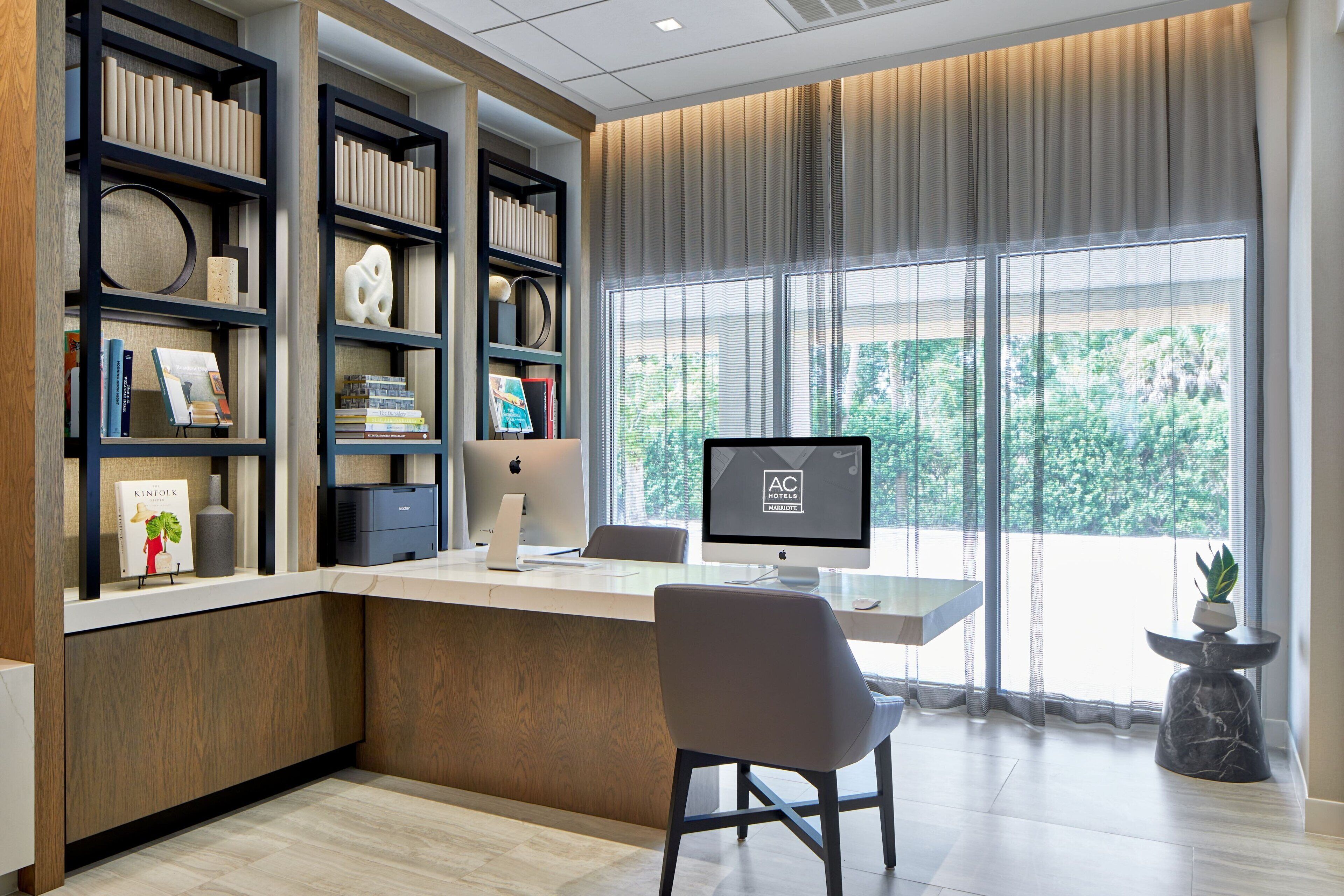Ein modernes Büro mit Schreibtisch, Computer und Bücherregalen.