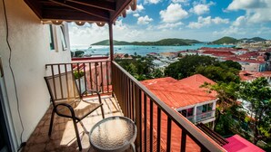 Un balcon donnant sur une ville côtière, avec vue sur les bâtiments et les bateaux.