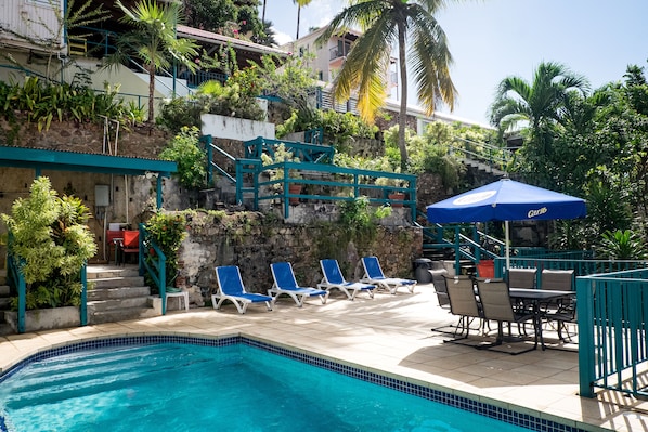 Una piscina al aire libre, sillones reclinables de piscina