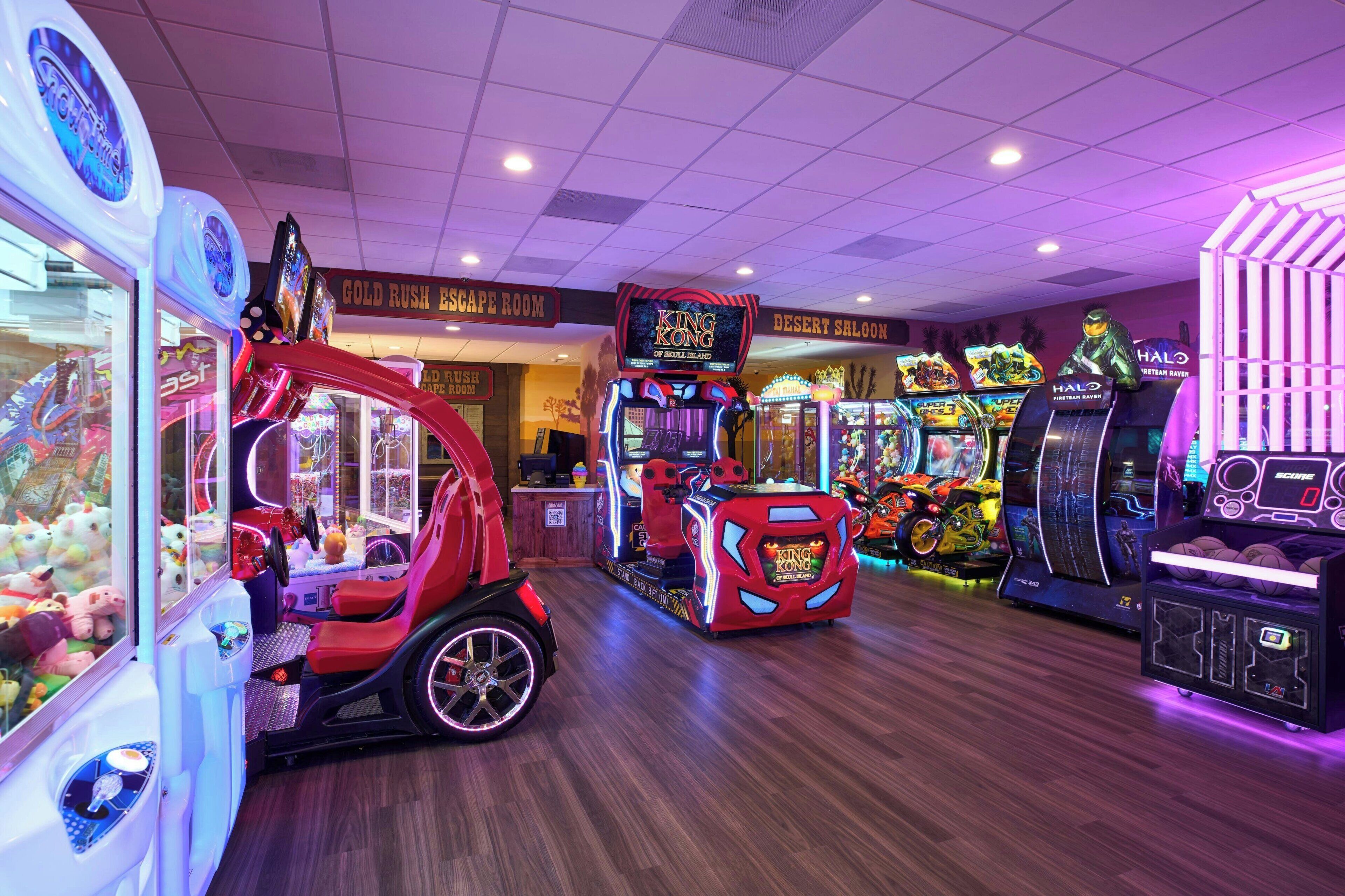 An indoor arcade with claw machines, racing games, and a 'King Kong' game.