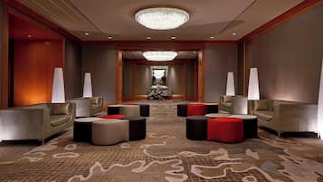 A spacious lobby with a chandelier, sofas, and a patterned carpet.