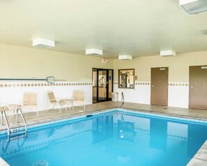 A swimming pool with a tiled border, a door, and a chair near the pool.