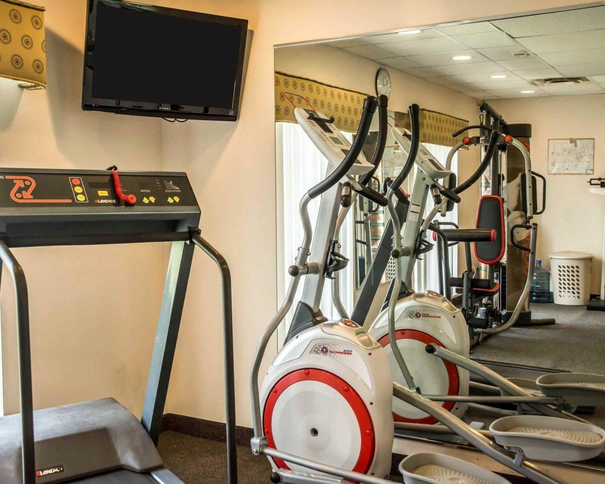 A gym with treadmills, ellipticals, and a stationary bike.