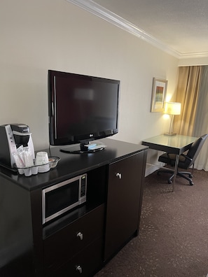 A hotel room with a flat-screen TV, a coffee maker, a desk, a chair, and a lamp. - Holiday Inn Tyler-Conference Center by IHG (Tyler)