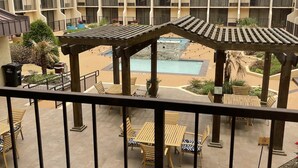 A hotel courtyard with outdoor seating, a pool, and a multi-story building with balconies. - Holiday Inn Tyler-Conference Center by IHG (Tyler)
