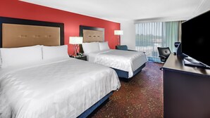 A hotel room with two beds, a desk, and a TV. - Holiday Inn Tyler-Conference Center by IHG (Tyler)
