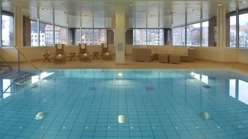 Una piscina techada, sillones reclinables de piscina