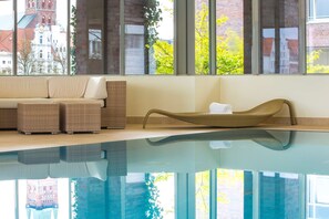 Una piscina techada, sillones reclinables de piscina