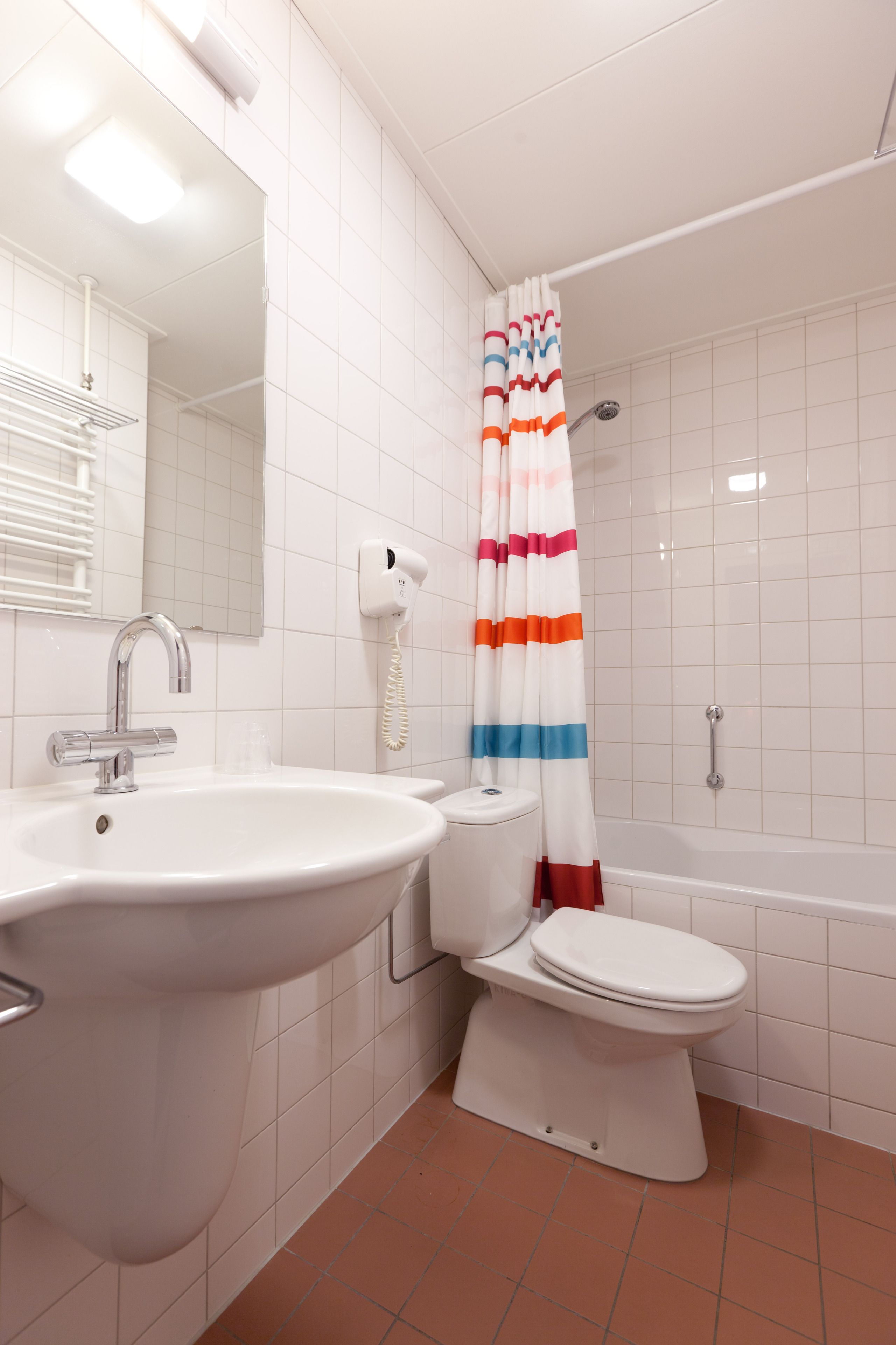 A bathroom with a white sink, toilet, and bathtub.