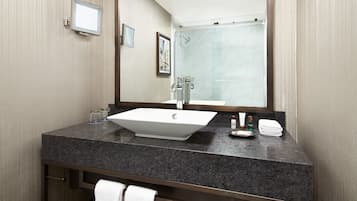 Un baño moderno con un espejo grande, un lavabo y una ducha.
