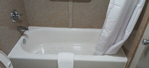 A white bathtub with a shower curtain, a towel, and a chrome faucet.