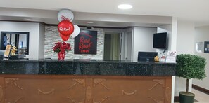 Un comptoir d’accueil d’hôtel avec une enseigne indiquant « Red Roof Inn ».