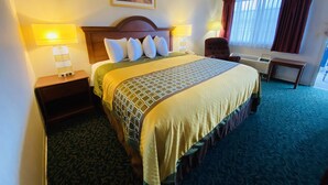 A hotel room with a large bed, two bedside lamps, a desk, and a chair.