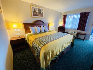 Relax in a spacious room with a large bed, two bedside tables, and a framed painting above.