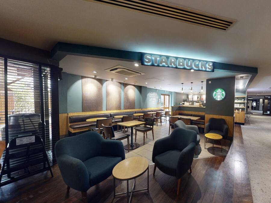 A Starbucks with seating areas, tables, and a counter.