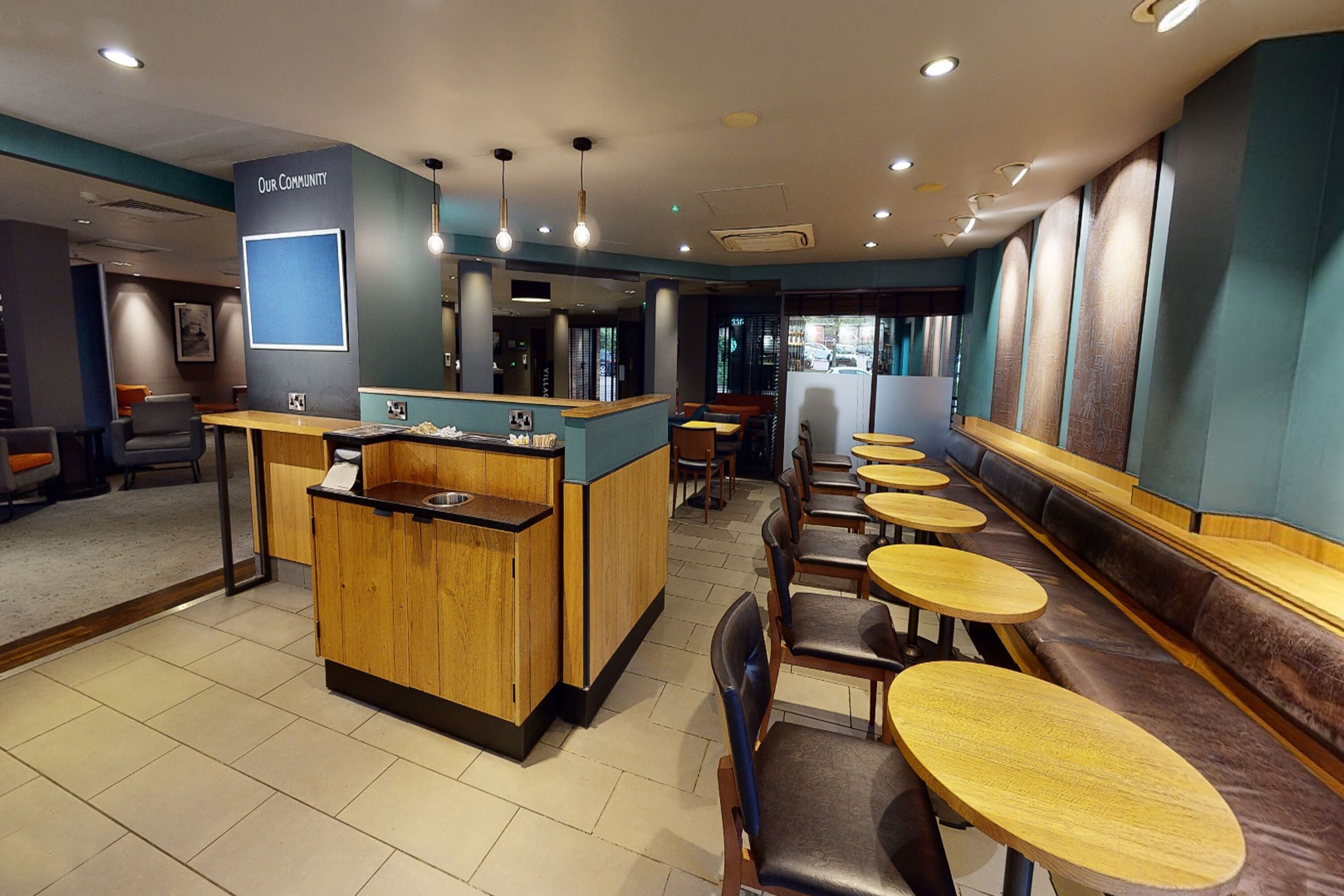 A restaurant interior with a counter, seating area, and a 'Our Community' sign.