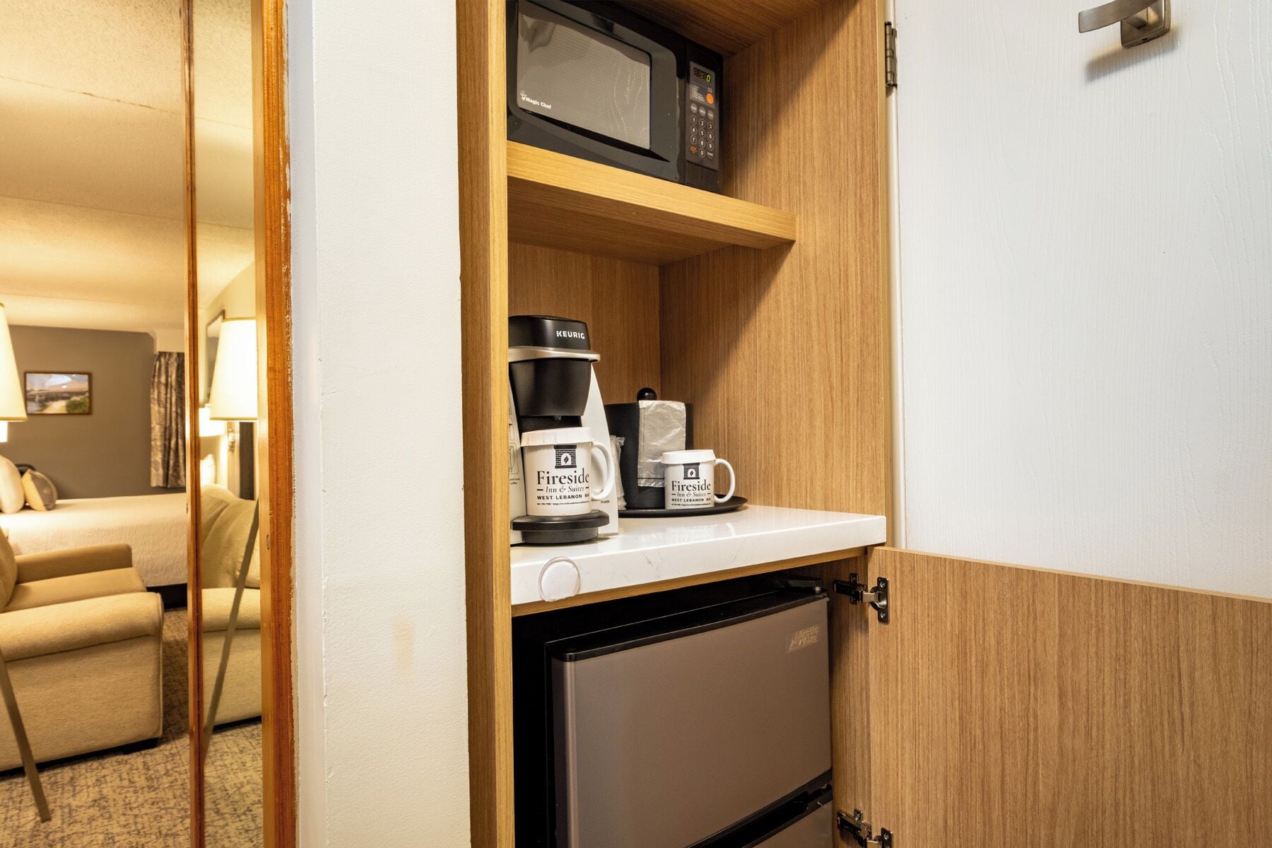 Une chambre d’hôtel dotée d’un coin cuisine comprenant un four à micro-ondes, une machine à café et un réfrigérateur.