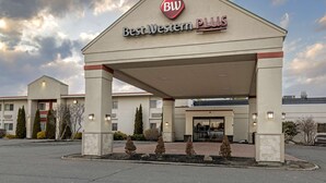A Best Western Plus hotel entrance with a covered walkway, a landscaped area with small trees, and a clear sky. - Best Western Plus Augusta Civic Center Inn (Augusta)