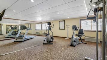 A gym with treadmills, elliptical machines, and a stationary bike.