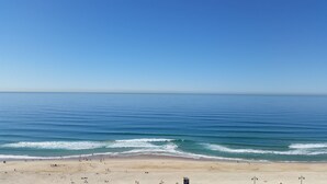 Une plage avec un ciel dégagé et une mer calme.