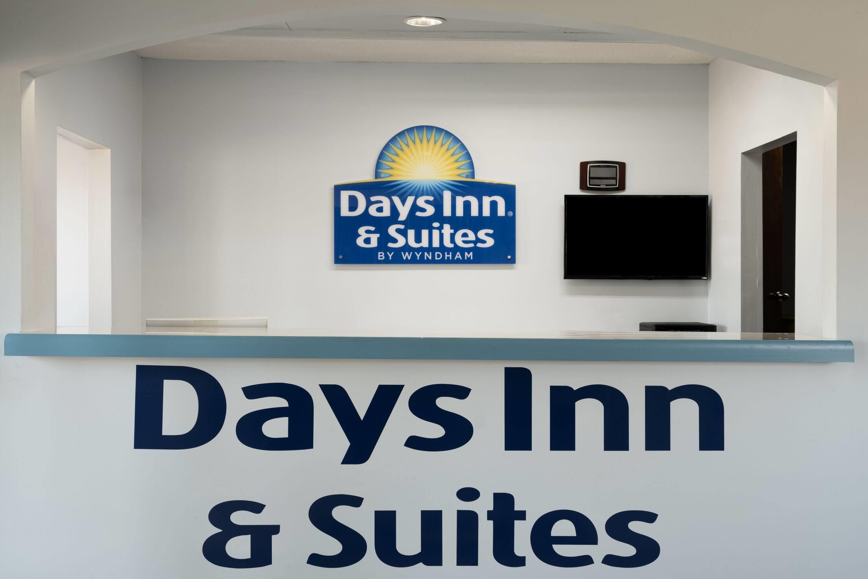 Een receptiebalie met een bord voor Days Inn & Suites by Wyndham.