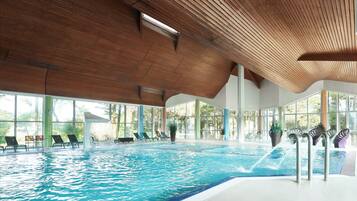 Een binnenzwembad, een buitenzwembad en parasols bij het zwembad