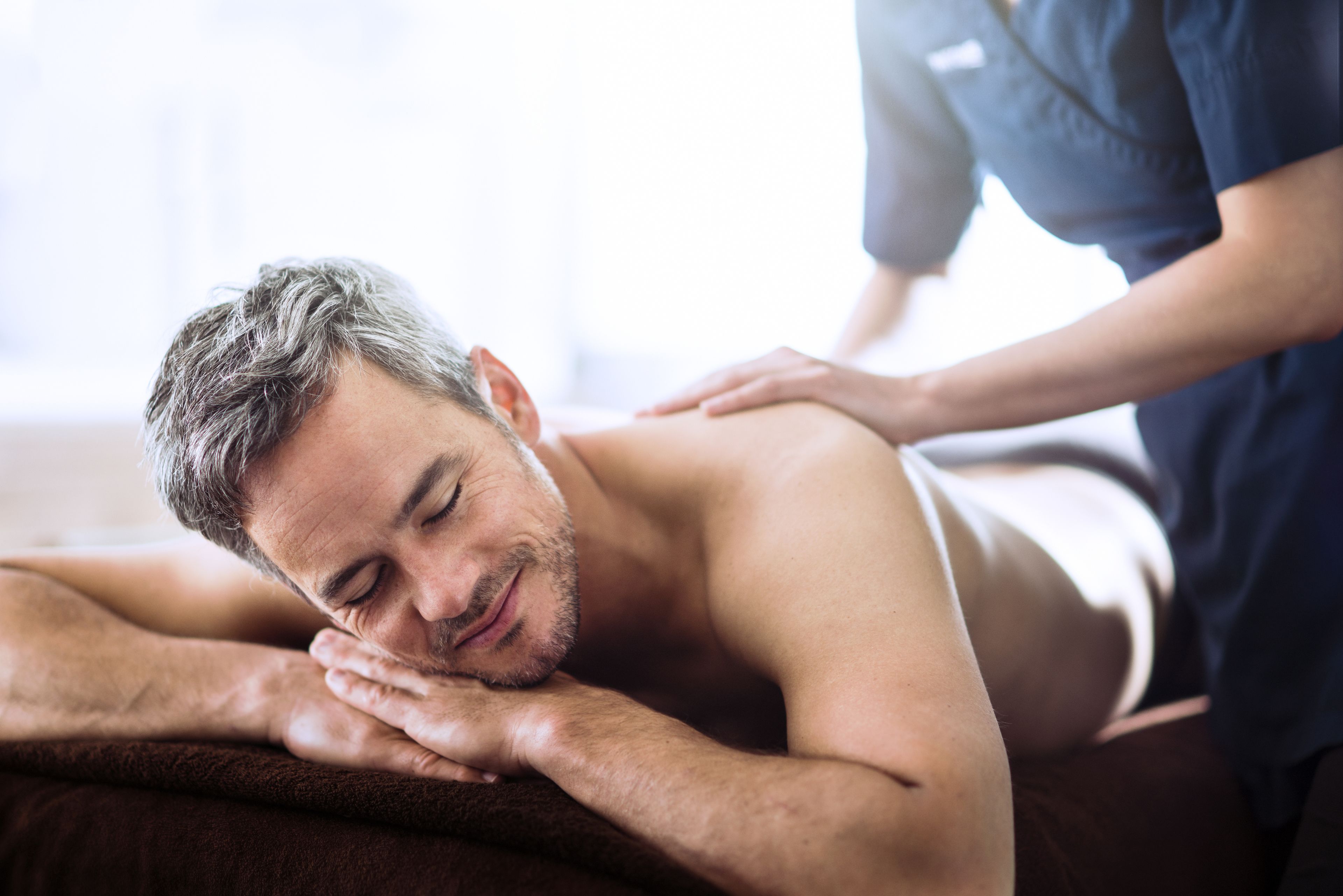 A person receiving a massage on a massage table.