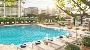 A swimming pool with lounge chairs and umbrellas, surrounded by greenery and buildings. - Frasers House, a Luxury Collection Hotel, Singapore (Singapore)