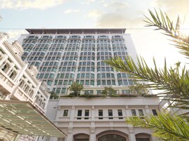 A multi-story hotel with a modern architectural design, featuring large windows and balconies.