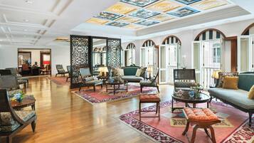 A spacious lobby with a high ceiling, ornate ceiling design, and traditional furniture.