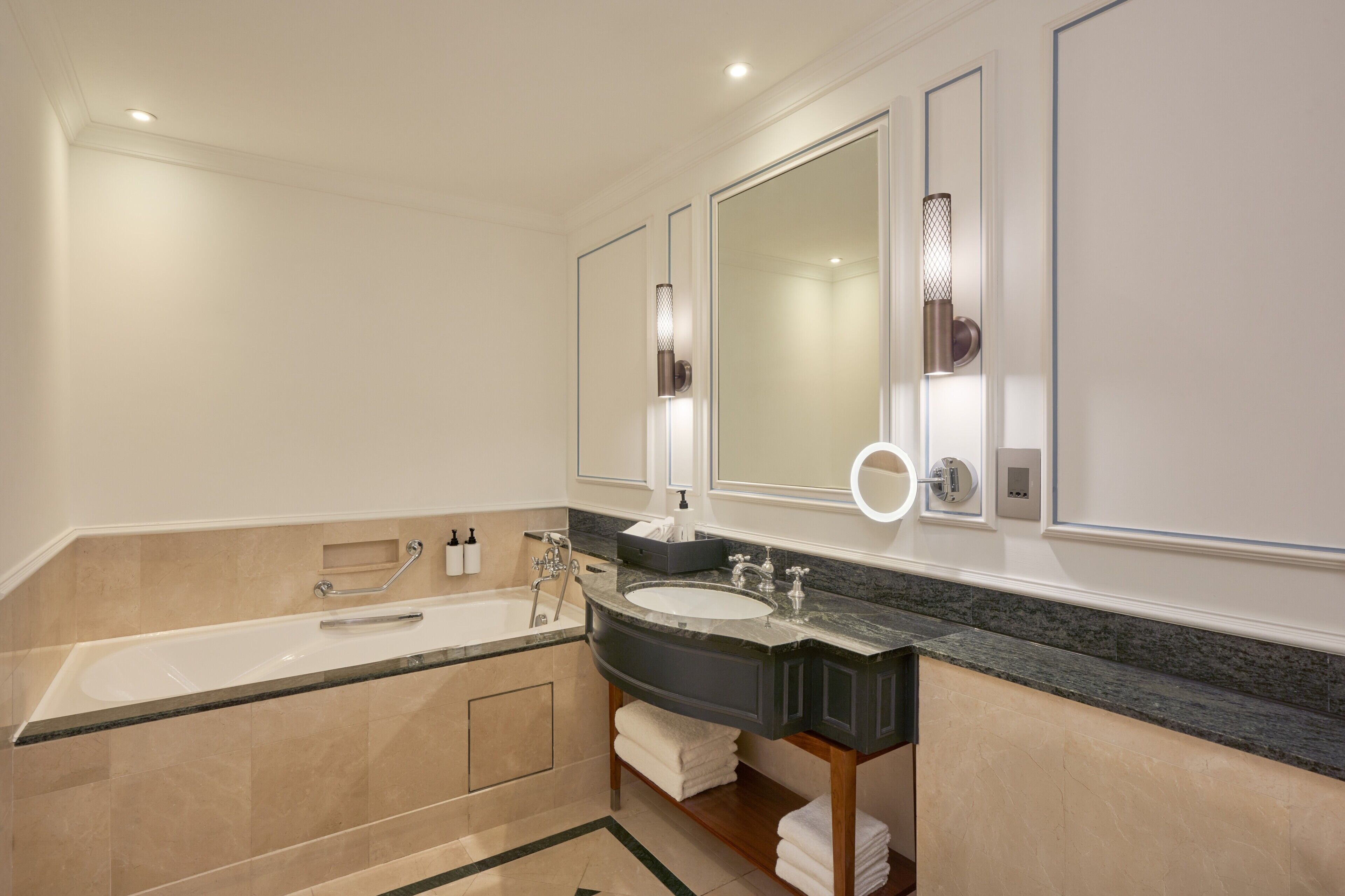 A modern bathroom with a bathtub, a sink, and a large mirror.