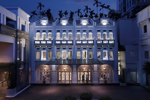 A multi-story hotel with a grand entrance, large windows, and a covered walkway.