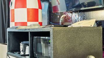 A space-themed decor with a rocket model, a television, and a shelf with a microwave.