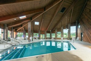 An indoor swimming pool with a high ceiling and large windows. - Baymont by Wyndham Louisville South/Shepherdsville/I 65 (Brooks)