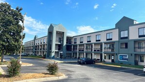 A multi-story hotel with a modern design, featuring balconies and a parking area. - Clarion Pointe - Greensboro Coliseum Area (Greensboro)