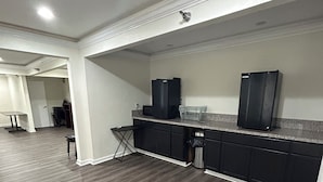 A modern kitchen with dark wood flooring, black cabinets, and stainless steel appliances. - Clarion Pointe - Greensboro Coliseum Area (Greensboro)