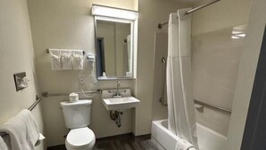 A bathroom with a toilet, sink, and shower. - Clarion Pointe - Greensboro Coliseum Area (Greensboro)