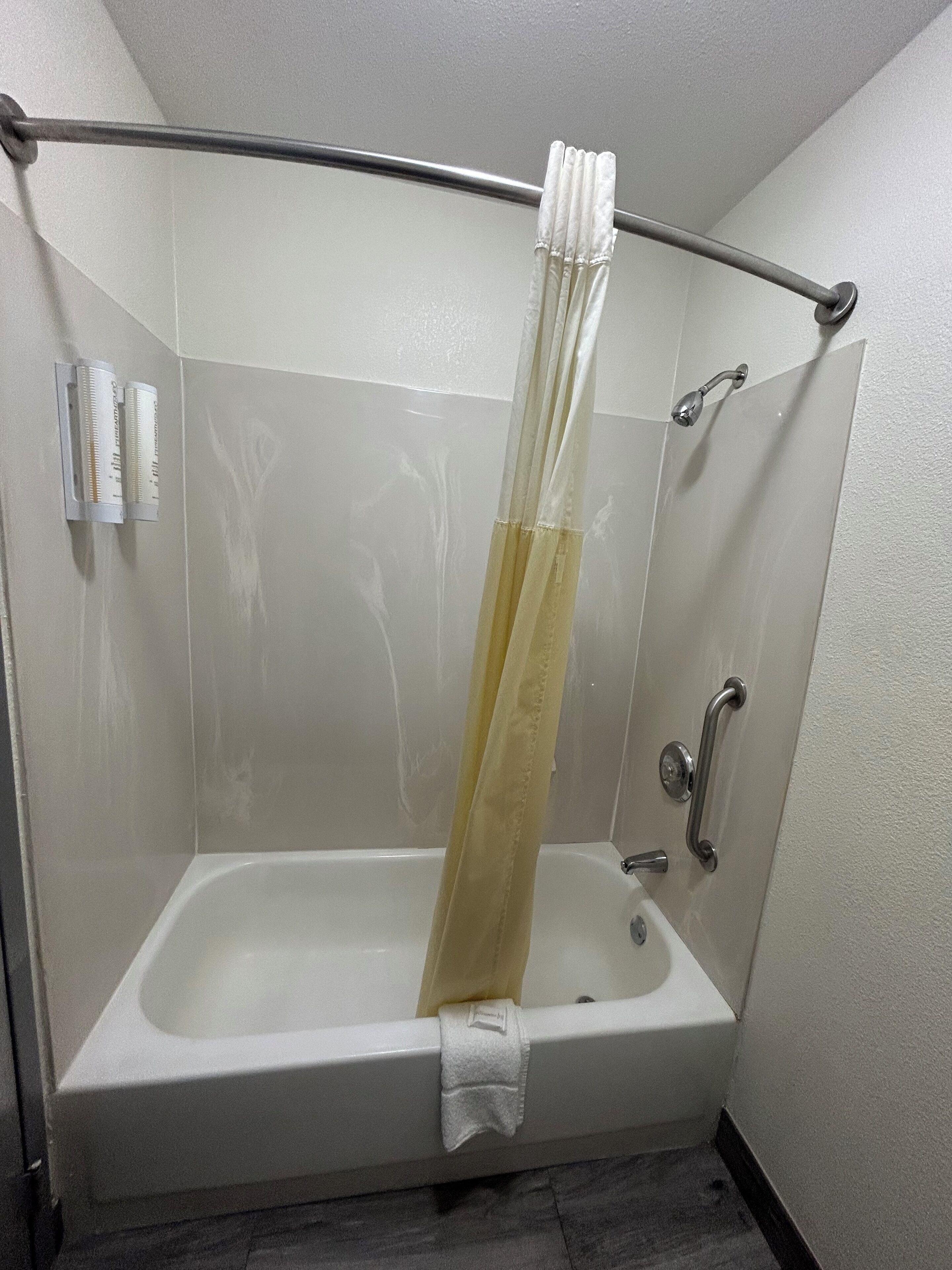 A shower with a glass door, a towel rack, and a handheld showerhead.