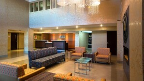 A spacious lobby with a reception desk, seating area, and a fireplace.