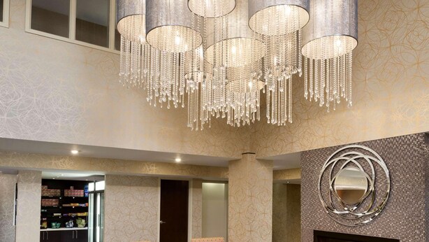 A spacious lobby with a large seating area, a fireplace, and a decorative chandelier.