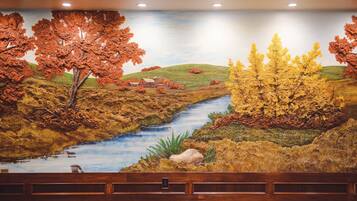 Un mural que muestra un río, árboles y un granero.
